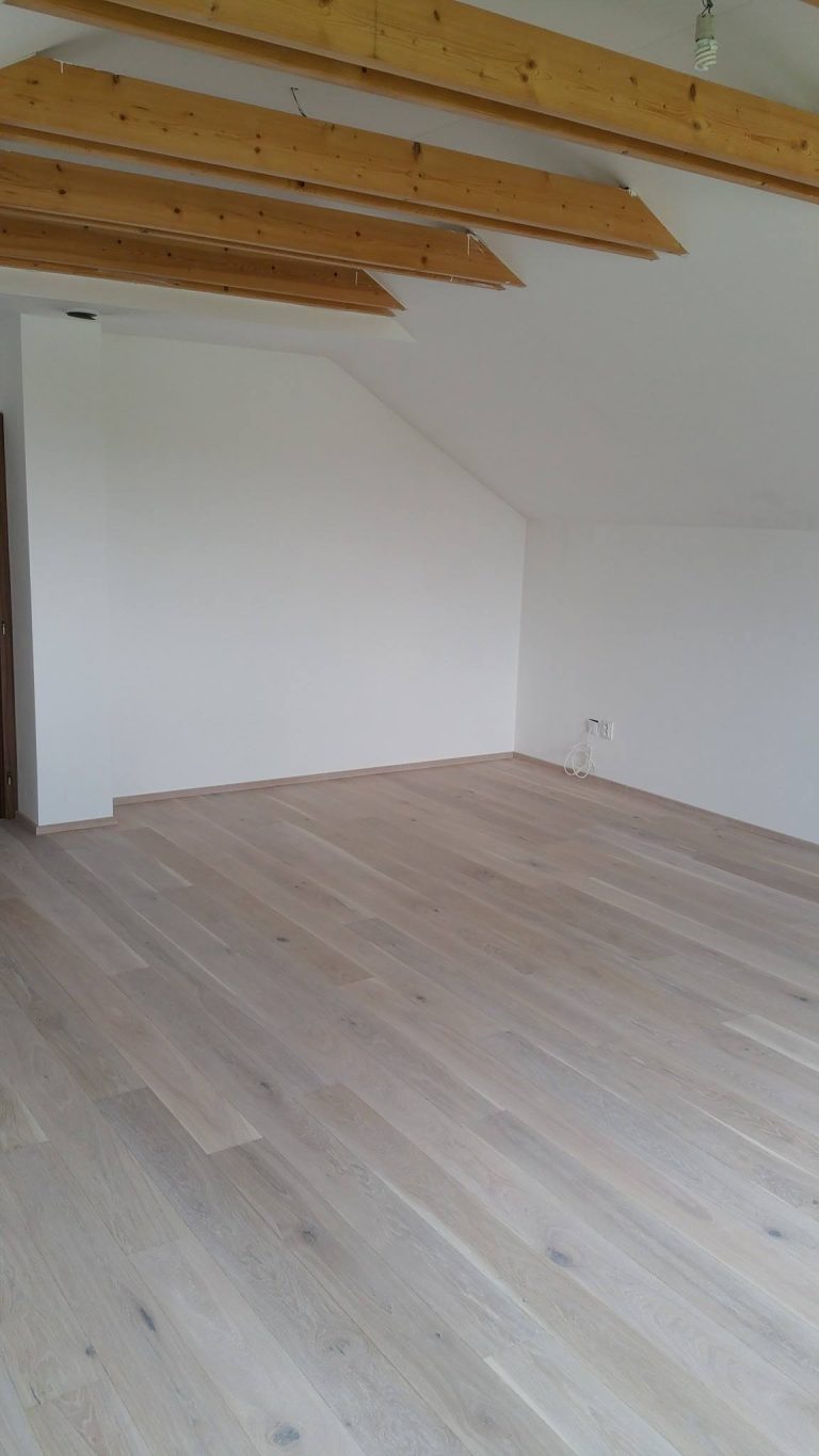 Dřevěná podlaha Dub bělený kartáčovaný – White Plains v obývacím pokoji rodinného domku. Povrch je ošetřený vodě a…